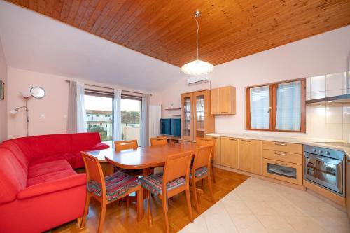 a living room with a red couch and a table at Inter-nautika doo in Jezera