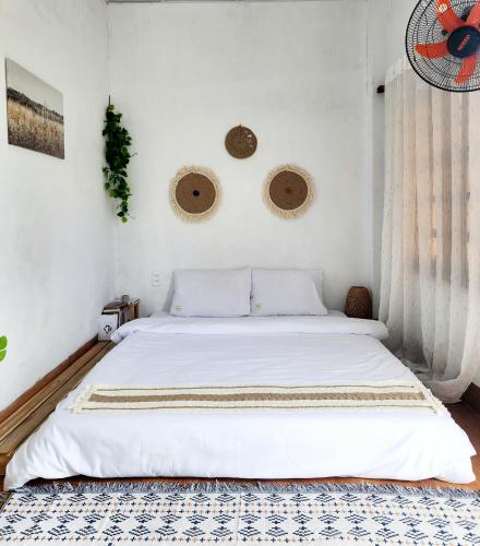 a bedroom with a large white bed with two mirrors at Muối Homestay in Ấp Khánh Phước (1)