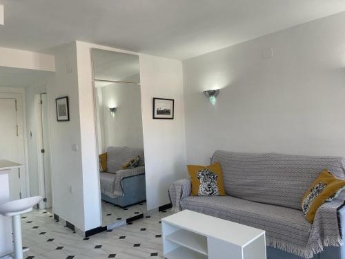 a living room with a couch and a mirror at Terrasol Estudios Plazamar in Torre del Mar