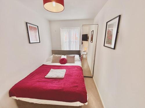a bedroom with a large bed with a red blanket at Nested 4-Bedrooms retreat in Walsall -Elegant 3 Bathrooms-Sleeps 9 in Walsall