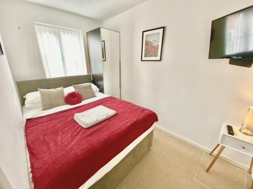 a bedroom with a large bed with a red blanket at Nested 4-Bedrooms retreat in Walsall -Elegant 3 Bathrooms-Sleeps 9 in Walsall