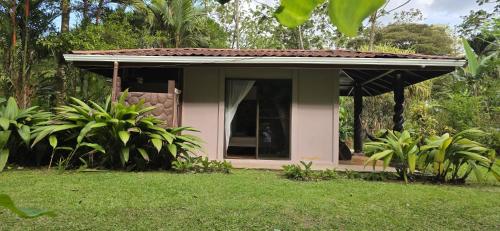 a small house with a window in a yard at Hotel Catarata Río Celeste in Bijagua