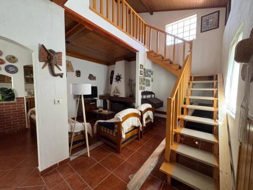 a living room with a staircase and a bedroom at Alojamento Praia do Norte in Leiria