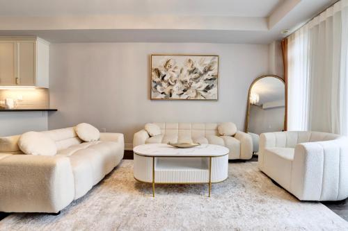 a living room with two couches and a table at Heart of Port Credit, Lakefront, Dining & Shopping in Mississauga