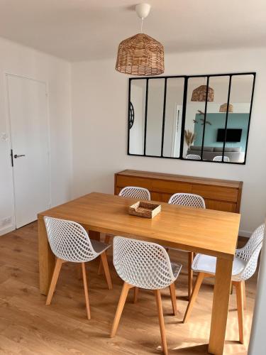 une salle à manger avec une table et des chaises en bois dans l'établissement Maison Kerheol, à Bénodet