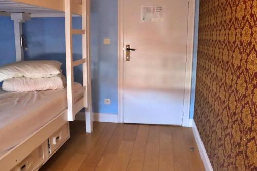 a room with two bunk beds and a door at Hostel Lybeer Bruges in Bruges