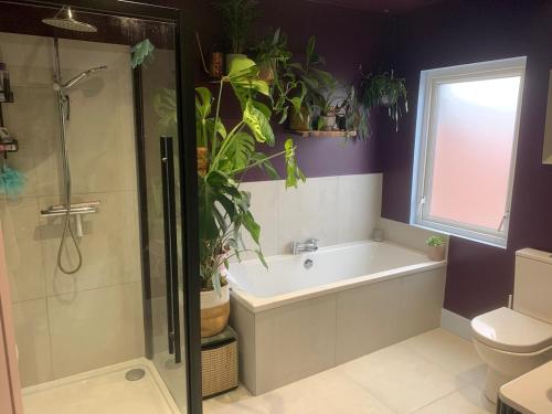 ベルファストにある3 bedroom house- East Belfastのバスルーム(バスタブ、シャワー、トイレ付)