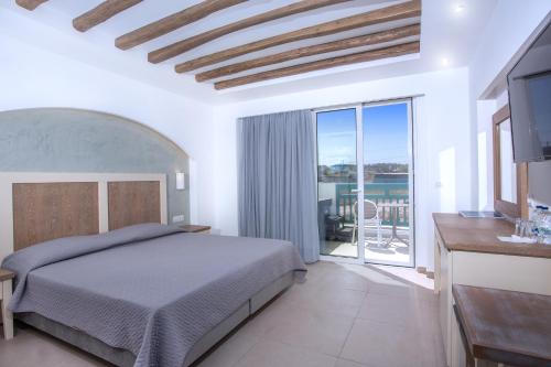 a bedroom with a bed and a balcony at Mastichari Bay Hotel in Mastichari