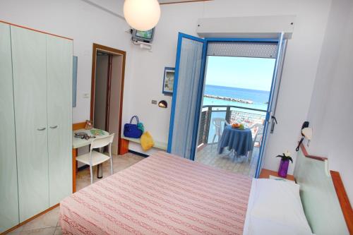 a bedroom with a bed and a view of the ocean at Hotel Bellaria in Bellaria-Igea Marina