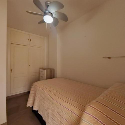 a bedroom with a bed and a ceiling fan at Terrasol Estudios Plazamar in Torre del Mar