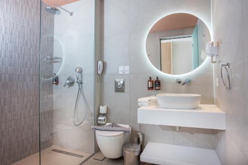 a bathroom with a toilet and a sink and a shower at Mastichari Bay Hotel in Mastihari
