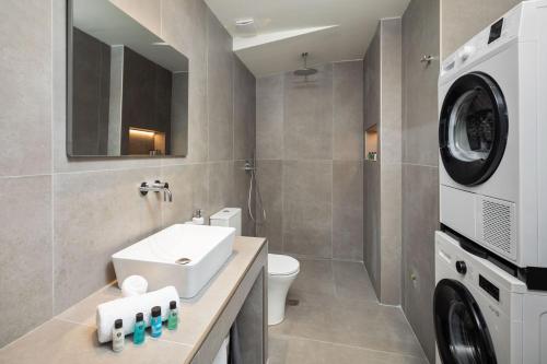 a bathroom with a sink and a washing machine at AGGELLE Villa in Potamós