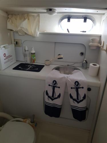 une salle de bain avec deux serviettes sur un lavabo dans un avion dans l'établissement Maison d'hôte de la mer-bateau à quai-SeaGuesthouse66, à Canet
