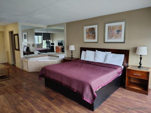 a hotel room with a bed and a bath tub at Allen Park Motor Lodge in Allen Park