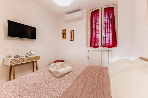 a bedroom with a bed with a tv on the wall at Trilocale vicino Metro B con Self Check In e Wi-Fi in Rome