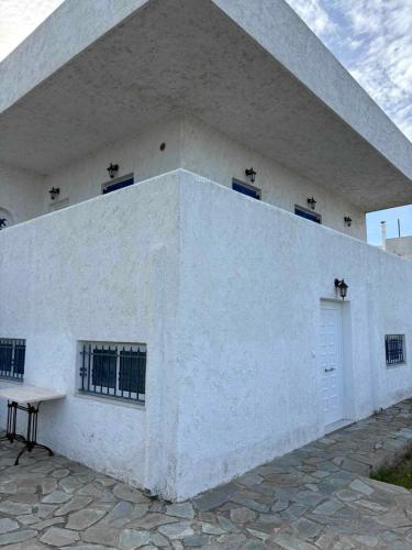 a white building with a bench in front of it at Kyriaki's Studio Aigina in Souvala