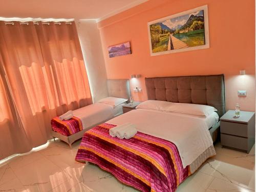 a bedroom with two beds and orange walls at Luna Guest House in Pisa