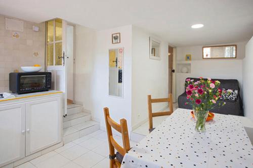 une cuisine et une table avec un vase de fleurs. dans l'établissement Bienvenue à La Garde, à La Garde