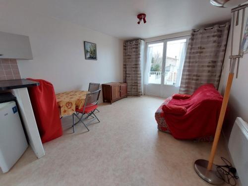- un salon avec un lit rouge et une table dans l'établissement Maison authentique 6 pers, plage du Pigeonnier, Royan - FR-1-550-87, à Royan
