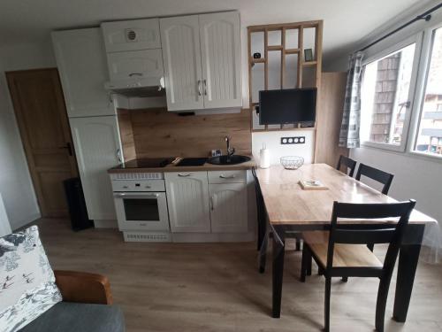 une cuisine avec une table en bois et une salle à manger dans l'établissement Studio cabine 4 pers 2* avec équipements pratiques à Valloire - FR-1-263-588, à Valloire