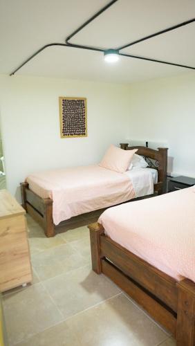 a bedroom with two beds and a painting on the wall at El Rancho de Salento in Salento