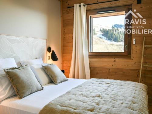 une chambre avec un grand lit et une fenêtre dans l'établissement Apt cocoon pour familles, vue montagne, parking, wifi - FR-1-391-207, au Grand-Bornand