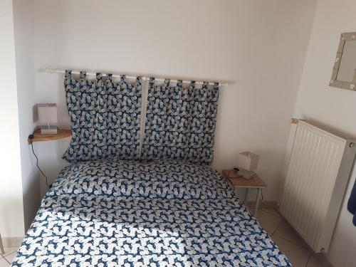 une chambre avec un lit avec une couette bleue et blanche dans l'établissement Charmant Pigeonnier rénové avec Wi-Fi, proche Port Bourgenay - FR-1-426-578, à Saint-Hilaire-de-Talmont