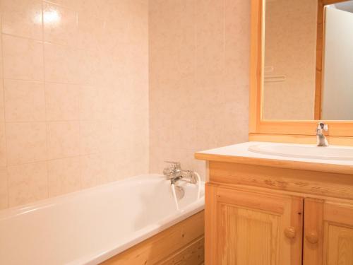 une salle de bain avec une baignoire blanche et un lavabo dans l'établissement Appartement accueillant 6 pers., Aussois calme & pratique - FR-1-508B-21, à Aussois