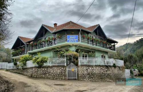 a large house with a fence in front of it at Privatan smeštaj Velić in Donji Milanovac