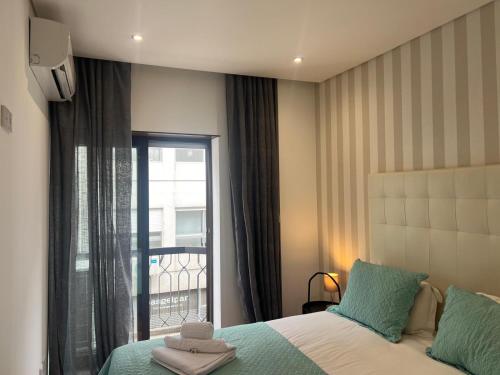 a bedroom with a bed and a window with a balcony at OPORTO APARTMENT LUXURY in Porto