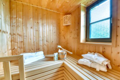 a sauna with towels in a wooden room at Ferienhaus Küstenkind Feriendorf 08 Klein Stresow Rügen by ruyastay in Putbus