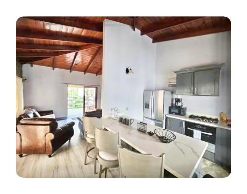 a kitchen and living room with a table and chairs at Renicas Cottage in Micoud