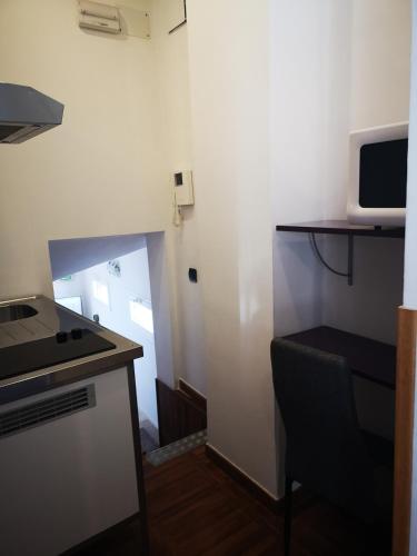 a small kitchen with a stove and a microwave at hospederia rincon de leon in León