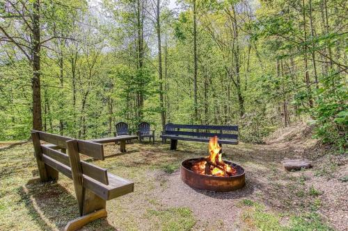 two benches and a fire pit in the woods at Our Mountain Memories by Avada Properties in Pigeon Forge