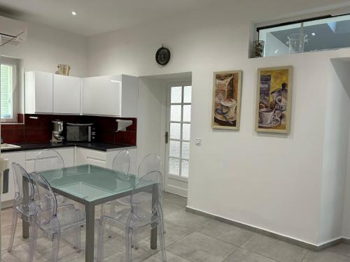 - une cuisine avec une table en verre et des chaises dans l'établissement Appart hyper centre Nice, à Nice