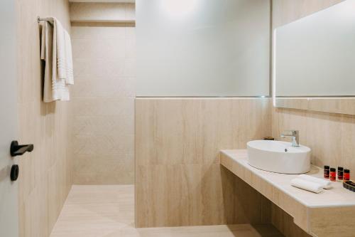 a bathroom with a white sink and a shower at Arcade Hotel Athens in Athens