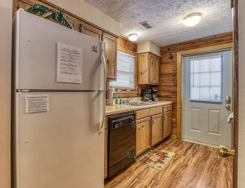 a kitchen with a stainless steel refrigerator and wooden cabinets at Our Mountain Memories by Avada Properties in Pigeon Forge