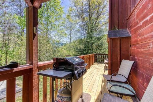 a screened in porch with a grill and chairs on it at Our Mountain Memories by Avada Properties in Pigeon Forge