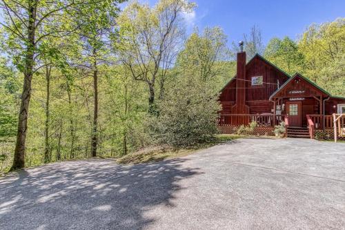 a large red barn with a driveway in front of it at Our Mountain Memories by Avada Properties in Pigeon Forge
