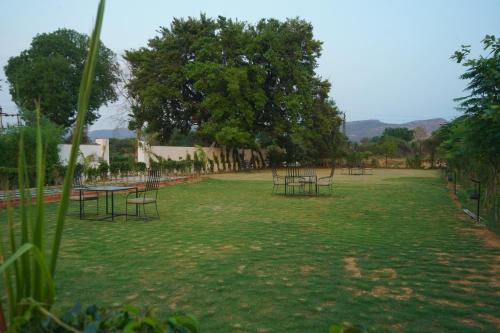 a park with tables and chairs in the grass at Sundervan Vilas Ranthambore in Khilchipur