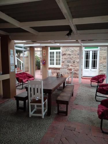 a patio with a wooden table and chairs at Twin Palms Accommodations in Mossel Bay