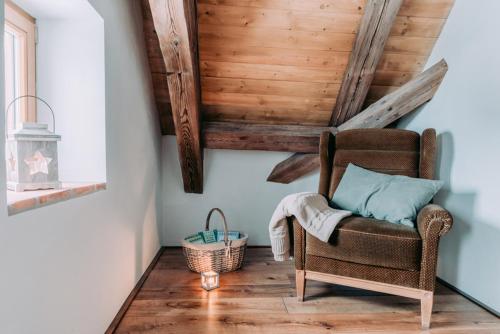 a room with a chair and a wooden ceiling at Apartmány Na Špejcharu in Stříbřec