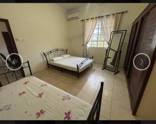 a bedroom with two beds and a window at Villa Zara in Zanzibar City