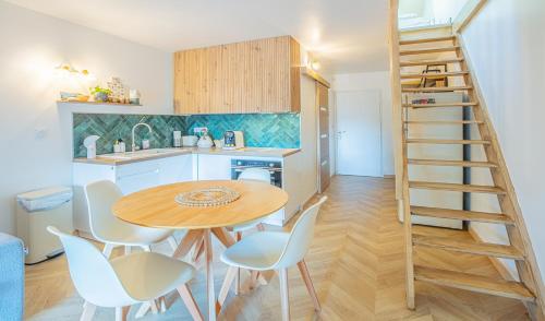une cuisine avec une table et des chaises ainsi qu'un escalier dans l'établissement La Galinette, Vue mer, Climatisation, Fibre, à Saint-Cyr-sur-Mer