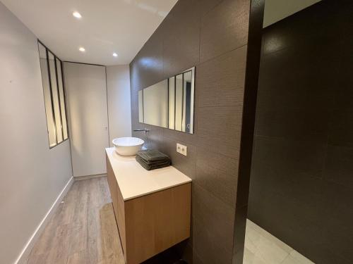 une salle de bain avec un lavabo et un miroir dans l'établissement Ancienne Boulangerie entièrement rénovée 5 Chambres 3 min métro 4 Barbara, à Montrouge