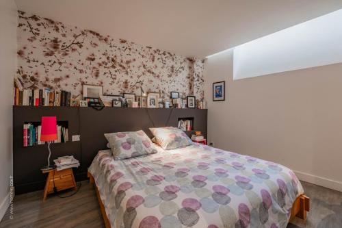 - une chambre avec un lit et une étagère avec des livres dans l'établissement Ancienne Boulangerie entièrement rénovée 5 Chambres 3 min métro 4 Barbara, à Montrouge