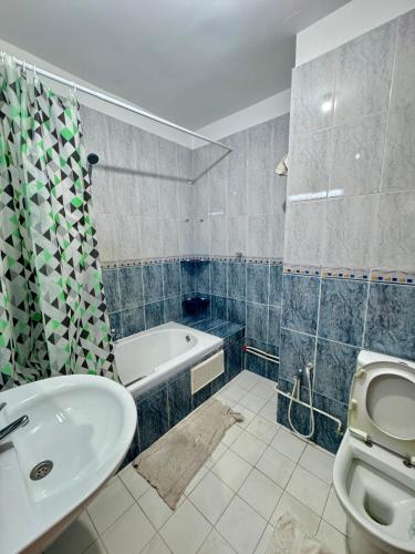 a bathroom with a sink and a toilet and a tub at Luxe & Sérénité suites in Bin Rhilouf