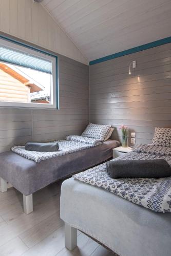 three beds in a room with a window at Gajowa Przystań in Sianozety
