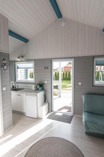 a kitchen in a tiny house with the door open at Gajowa Przystań in Sianozety