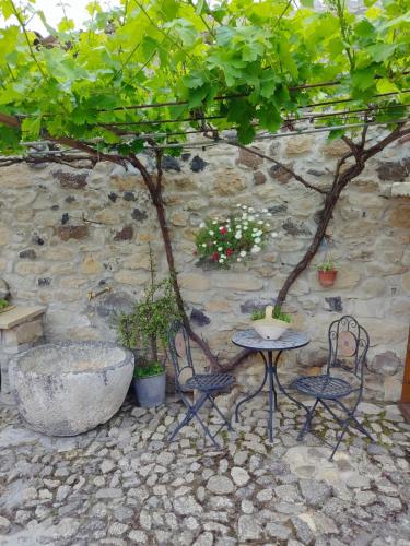 a table and chairs next to a stone wall at Casa museo "Sa domu de ziu Antoneddu" in Tuili